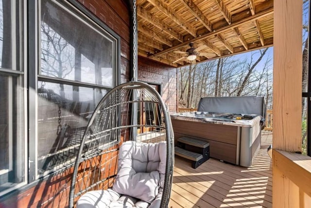 wooden terrace featuring a ceiling fan and a hot tub