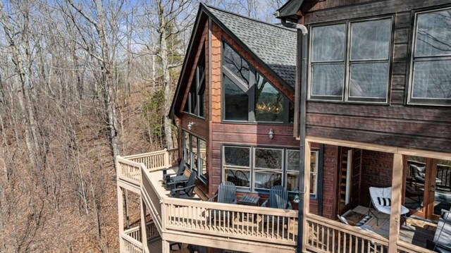 rear view of property with roof with shingles