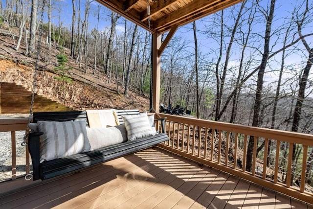 wooden terrace featuring a view of trees