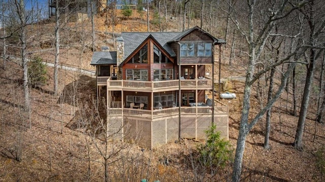 back of property featuring a wooden deck, a shingled roof, and a balcony