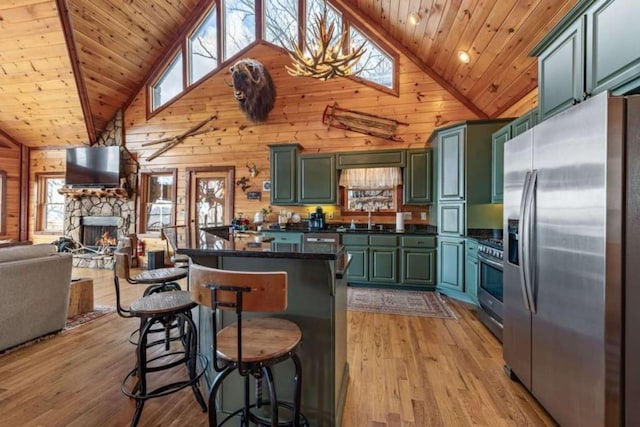 kitchen featuring green cabinetry, wooden walls, appliances with stainless steel finishes, and wood ceiling