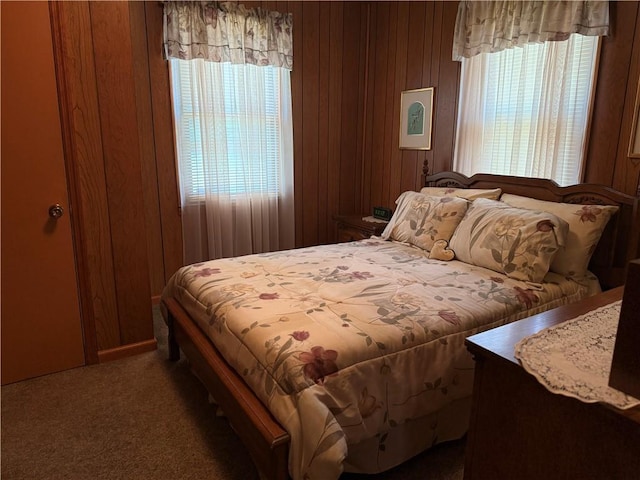 bedroom with carpet floors and wooden walls