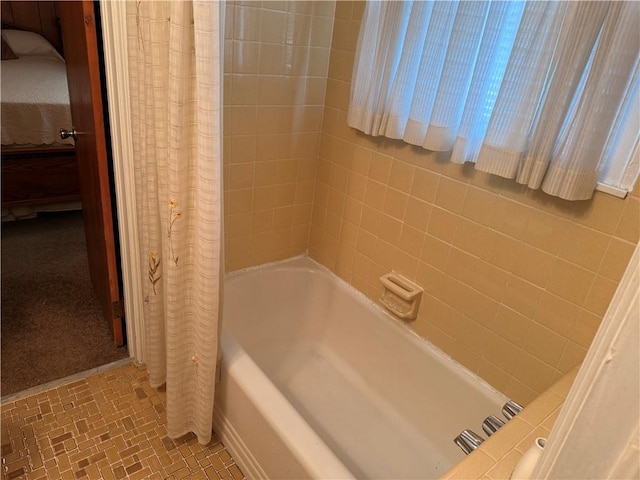 ensuite bathroom featuring shower / bathtub combination with curtain