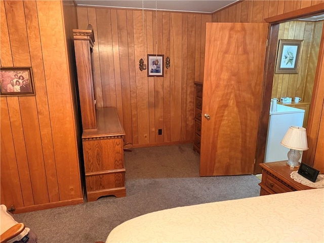 bedroom with carpet, wooden walls, and washer and dryer
