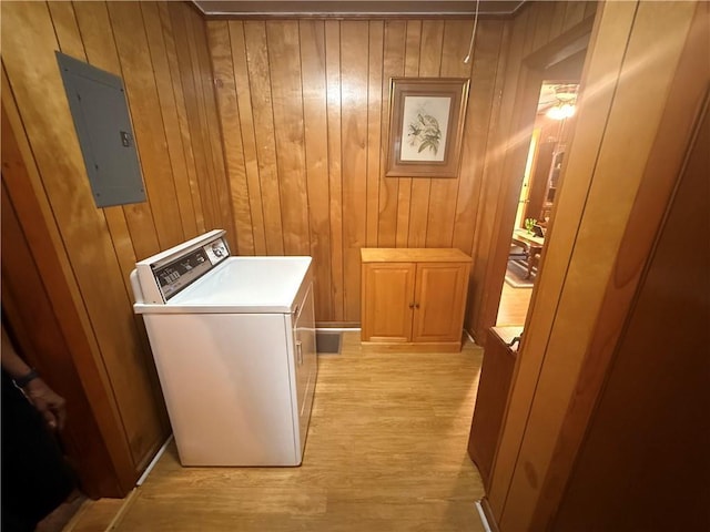 washroom featuring washer / dryer, electric panel, wood walls, and light wood finished floors