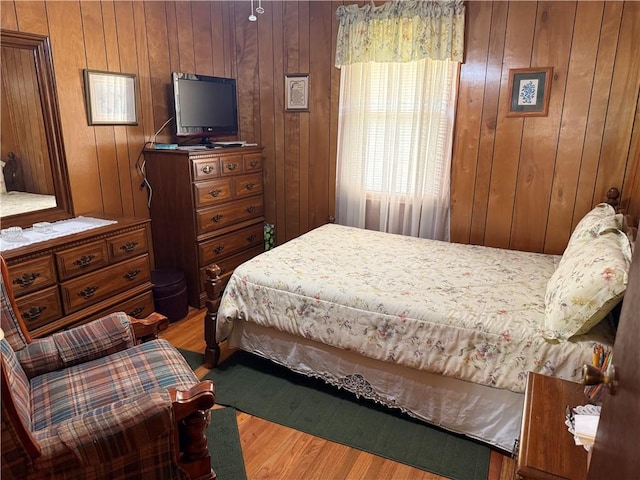 bedroom featuring wood finished floors and wood walls
