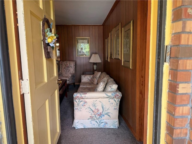 sitting room featuring carpet flooring and wood walls