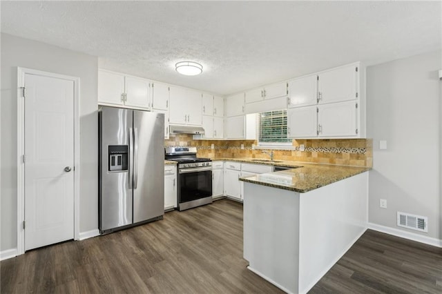2920 Cushing Ct, Jonesboro, GA 30236 - kitchen featuring stainless steel appliances, under cabinet range hood, dark wood finished floors, white cabinetry, and a peninsula
