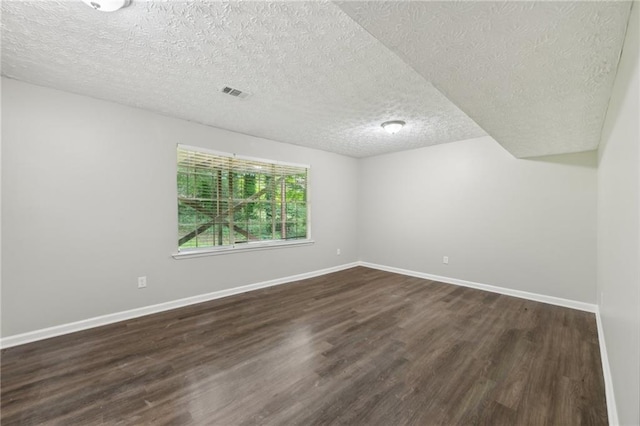 2920 Cushing Ct, Jonesboro, GA 30236 - spare room featuring dark wood-type flooring, a textured ceiling, and baseboards