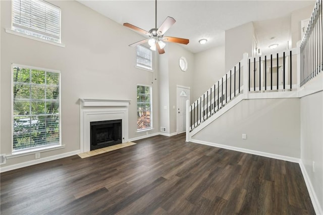 2920 Cushing Ct, Jonesboro, GA 30236 - unfurnished living room with a high ceiling, wood finished floors, ceiling fan, baseboards, and stairs