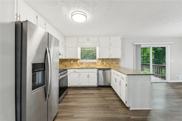 2920 Cushing Ct, Jonesboro, GA 30236 - kitchen with appliances with stainless steel finishes, a sink, a peninsula, dark wood-style floors, and a textured ceiling