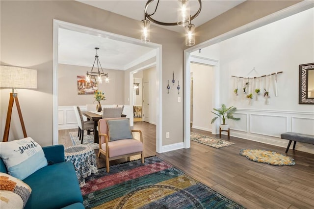 4266 Suwanee Brook Ct, Buford, GA 30518 - living area featuring a chandelier, a decorative wall, wood finished floors, and wainscoting