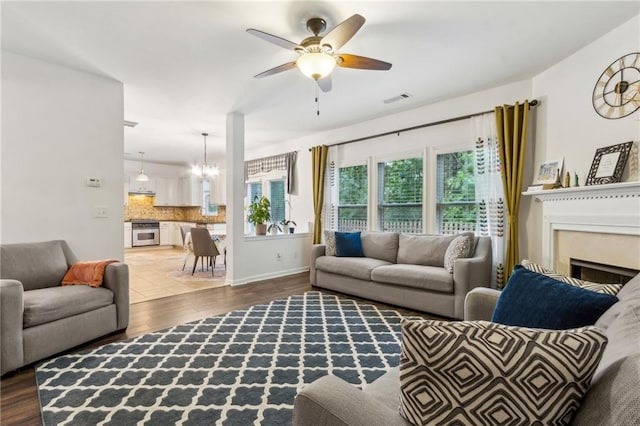 4266 Suwanee Brook Ct, Buford, GA 30518 - living area featuring ceiling fan, wood finished floors, a fireplace, a chandelier, and baseboards