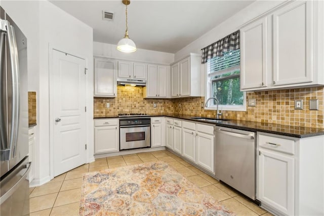 4266 Suwanee Brook Ct, Buford, GA 30518 - kitchen featuring appliances with stainless steel finishes, a sink, under cabinet range hood, light tile patterned floors, and decorative light fixtures
