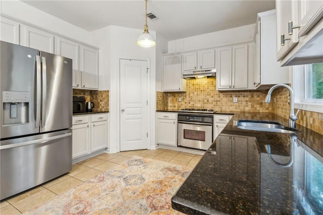 4266 Suwanee Brook Ct, Buford, GA 30518 - kitchen featuring stainless steel appliances, a sink, light tile patterned flooring, hanging light fixtures, and dark stone countertops