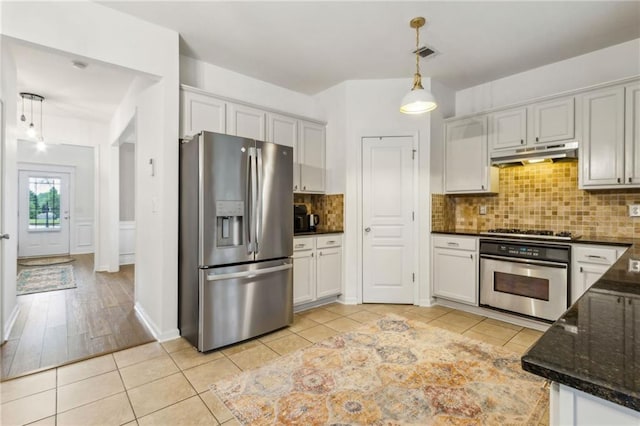 4266 Suwanee Brook Ct, Buford, GA 30518 - kitchen featuring appliances with stainless steel finishes, under cabinet range hood, tasteful backsplash, hanging light fixtures, and dark stone counters