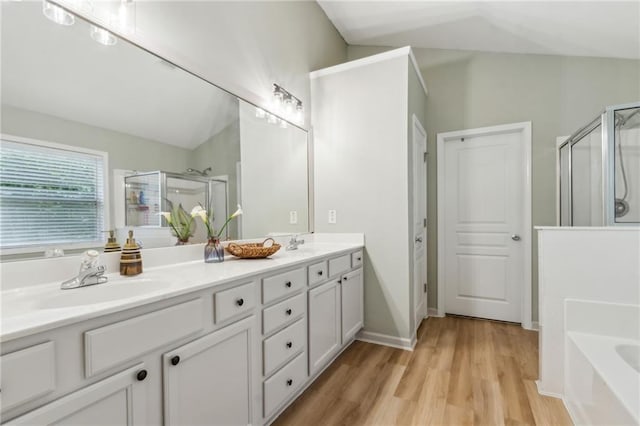 4266 Suwanee Brook Ct, Buford, GA 30518 - bathroom featuring lofted ceiling, a shower stall, a garden tub, double vanity, and wood finished floors