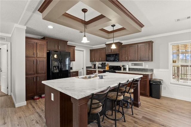 kitchen with visible vents, crown molding, light wood-type flooring, black appliances, and a sink