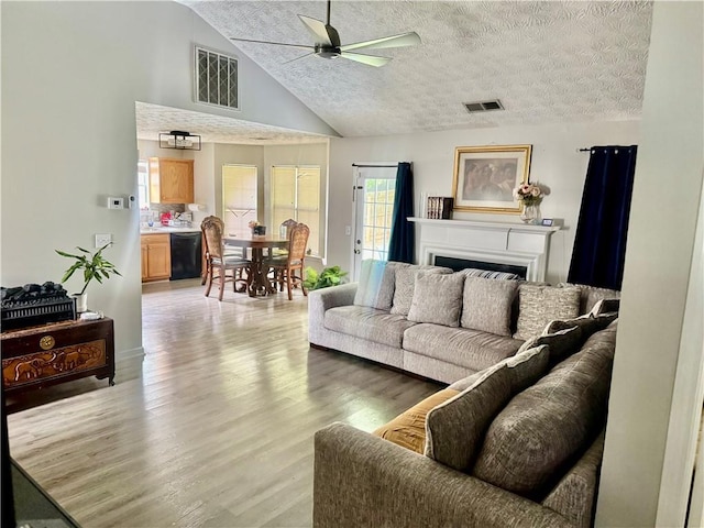 159 Misty Ridge Trl, Stockbridge, GA 30281 - living room with a ceiling fan, light wood-style flooring, a textured ceiling, high vaulted ceiling, and a fireplace