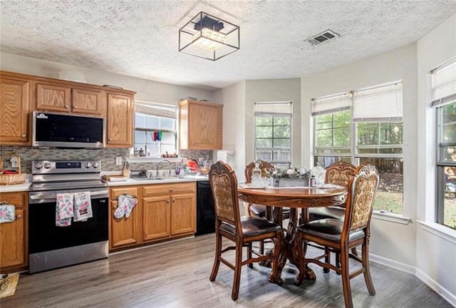159 Misty Ridge Trl, Stockbridge, GA 30281 - kitchen featuring appliances with stainless steel finishes, a sink, backsplash, light wood-style flooring, and light countertops