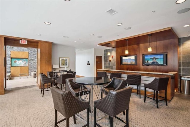 bar with light colored carpet and pendant lighting