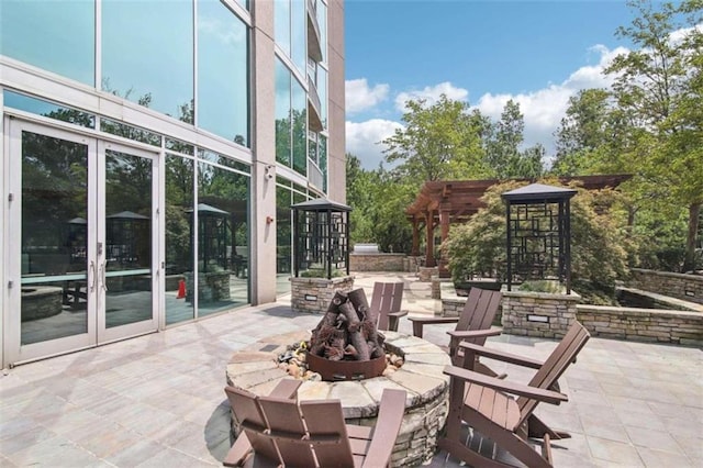 view of patio featuring french doors, a pergola, and an outdoor fire pit