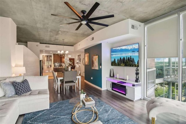 living room featuring dark wood-type flooring and ceiling fan with notable chandelier