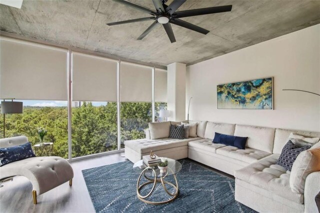 living room with ceiling fan, expansive windows, and a healthy amount of sunlight