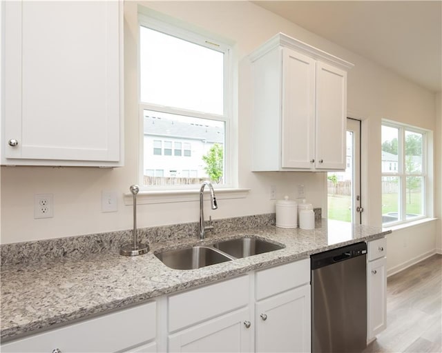 1577 Aiden Way Unit 39, Conyers, GA 30013 - kitchen with stainless steel dishwasher, a sink, white cabinetry, wood finished floors, and light stone counters