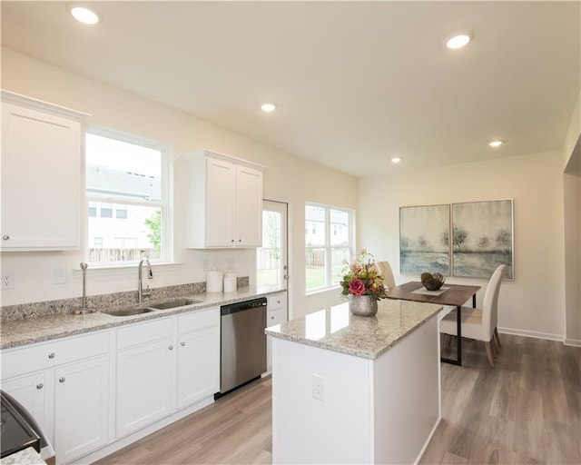 1577 Aiden Way Unit 39, Conyers, GA 30013 - kitchen featuring dishwasher, a sink, light wood finished floors, white cabinets, and a kitchen island