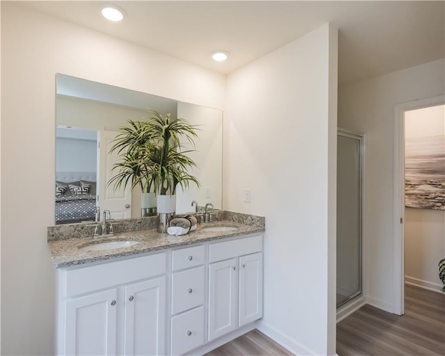 1577 Aiden Way Unit 39, Conyers, GA 30013 - full bath featuring wood finished floors, double vanity, baseboards, and a shower stall
