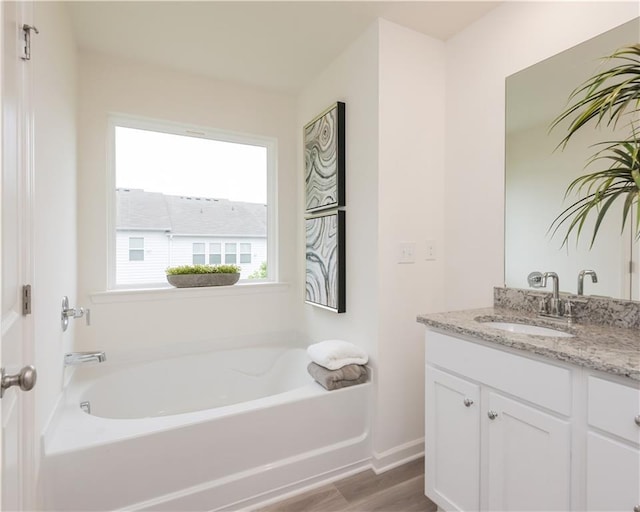 1577 Aiden Way Unit 39, Conyers, GA 30013 - bathroom with vanity, a garden tub, wood finished floors, and baseboards