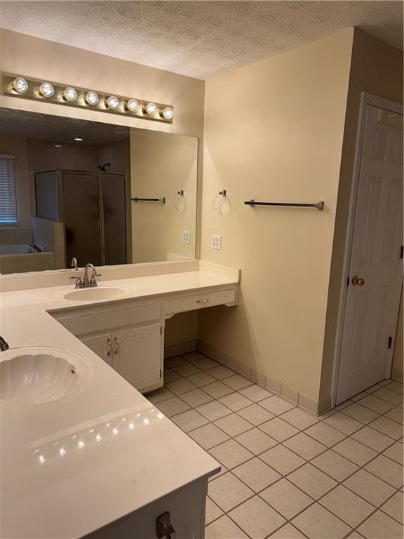 bathroom featuring tile patterned flooring, shower with separate bathtub, vanity, and a textured ceiling