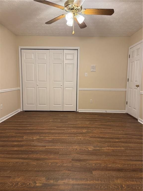 unfurnished bedroom with ceiling fan, dark hardwood / wood-style floors, a textured ceiling, and a closet