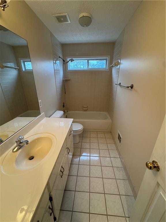 full bathroom with tile patterned floors, a wealth of natural light, a textured ceiling, and toilet