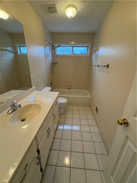 full bathroom featuring a textured ceiling, tile patterned flooring, toilet, and a wealth of natural light