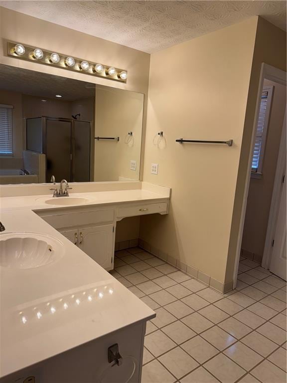 bathroom with vanity, shower with separate bathtub, a textured ceiling, and tile patterned floors