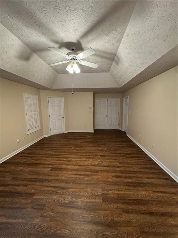 additional living space with a textured ceiling, dark wood-type flooring, lofted ceiling, and ceiling fan