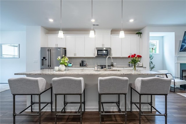 3518 Mount Blue Ave, Tucker, GA 30084 - kitchen with appliances with stainless steel finishes, a kitchen island with sink, a sink, tasteful backsplash, and white cabinets