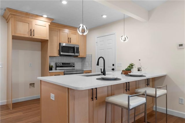 kitchen featuring sink, appliances with stainless steel finishes, backsplash, decorative light fixtures, and kitchen peninsula