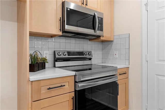 kitchen with appliances with stainless steel finishes, light brown cabinetry, and decorative backsplash