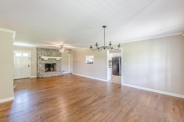 7928 S Giles Rd, Douglasville, GA 30135 - unfurnished living room with crown molding, a chandelier, a fireplace, a ceiling fan, and light wood finished floors