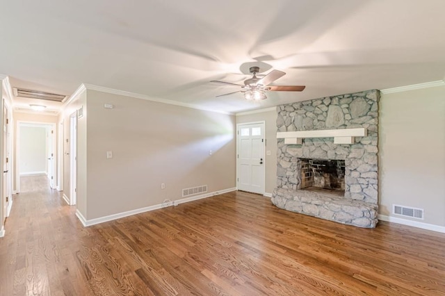 7928 S Giles Rd, Douglasville, GA 30135 - unfurnished living room featuring ceiling fan, crown molding, wood finished floors, baseboards, and a stone fireplace