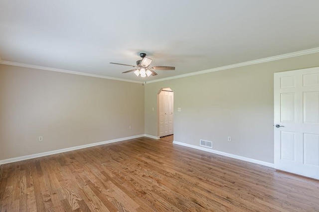 7928 S Giles Rd, Douglasville, GA 30135 - empty room featuring crown molding, a ceiling fan, arched walkways, baseboards, and wood finished floors
