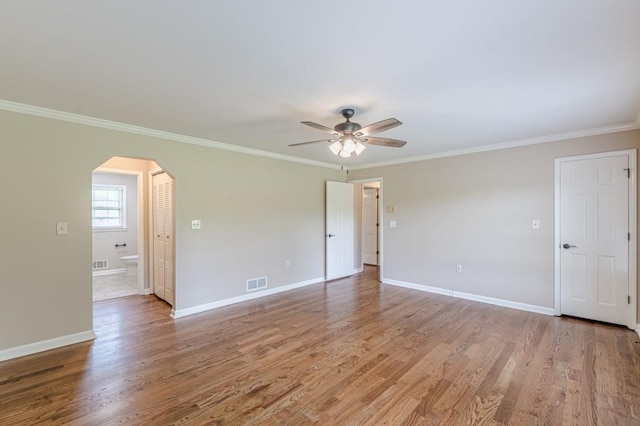 7928 S Giles Rd, Douglasville, GA 30135 - spare room with arched walkways, ornamental molding, a ceiling fan, baseboards, and light wood-style floors