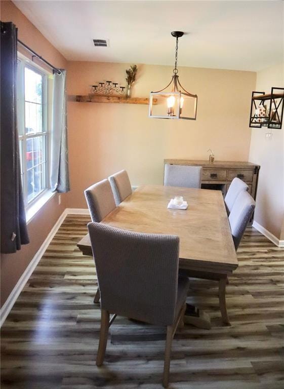 dining room with a chandelier and dark hardwood / wood-style flooring