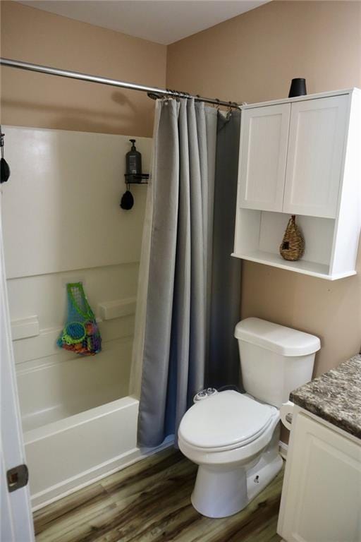 full bathroom with toilet, hardwood / wood-style floors, vanity, and shower / tub combo with curtain