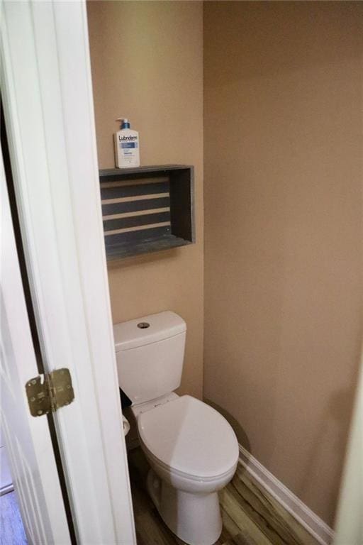 bathroom with hardwood / wood-style floors and toilet