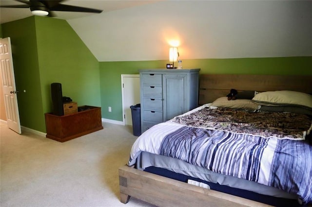 carpeted bedroom with ceiling fan and vaulted ceiling