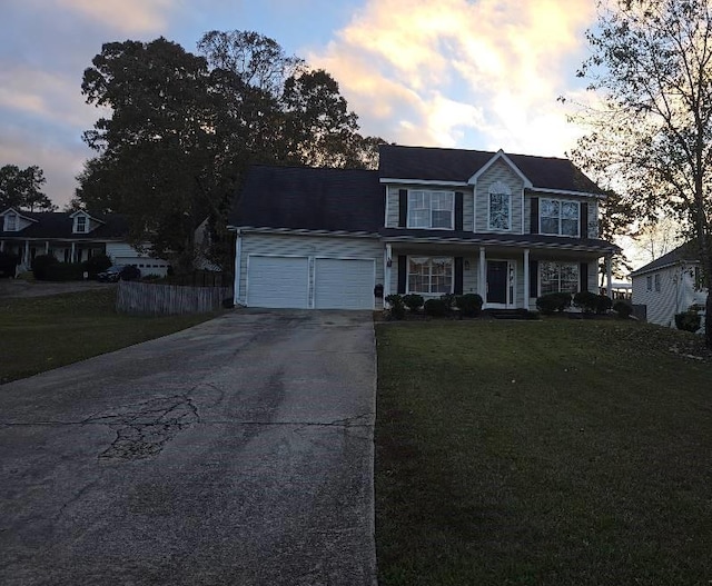 colonial house featuring a garage and a yard